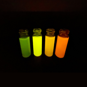 Fluorescent chemical samples glowing under during laboratory analysis.